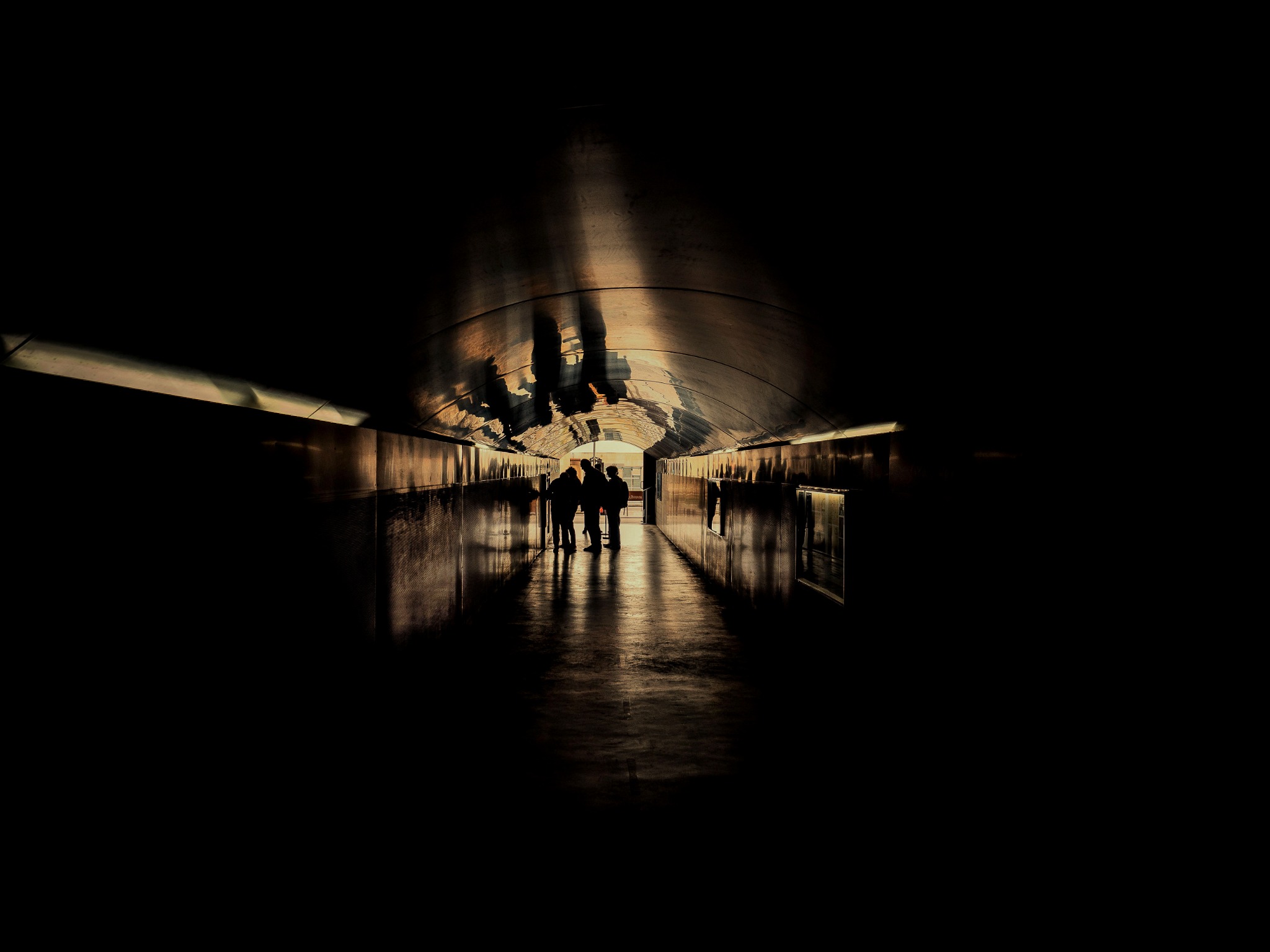 Corridoio scuro con figure in controluce